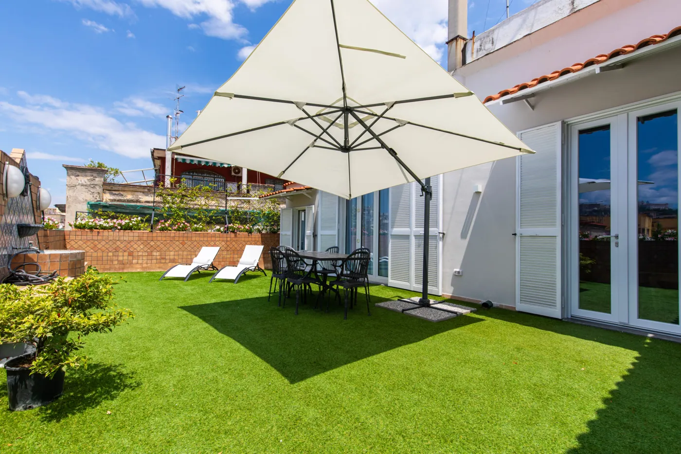 Terrazzo di Le Dome 35 con ombrellone e area verde